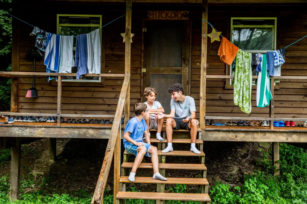 Campers sitting outside cabin talking