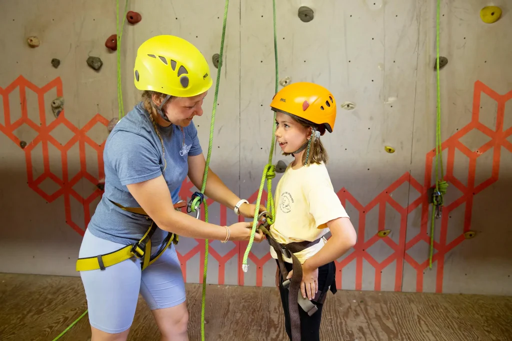 Staff and camper preparing to climb