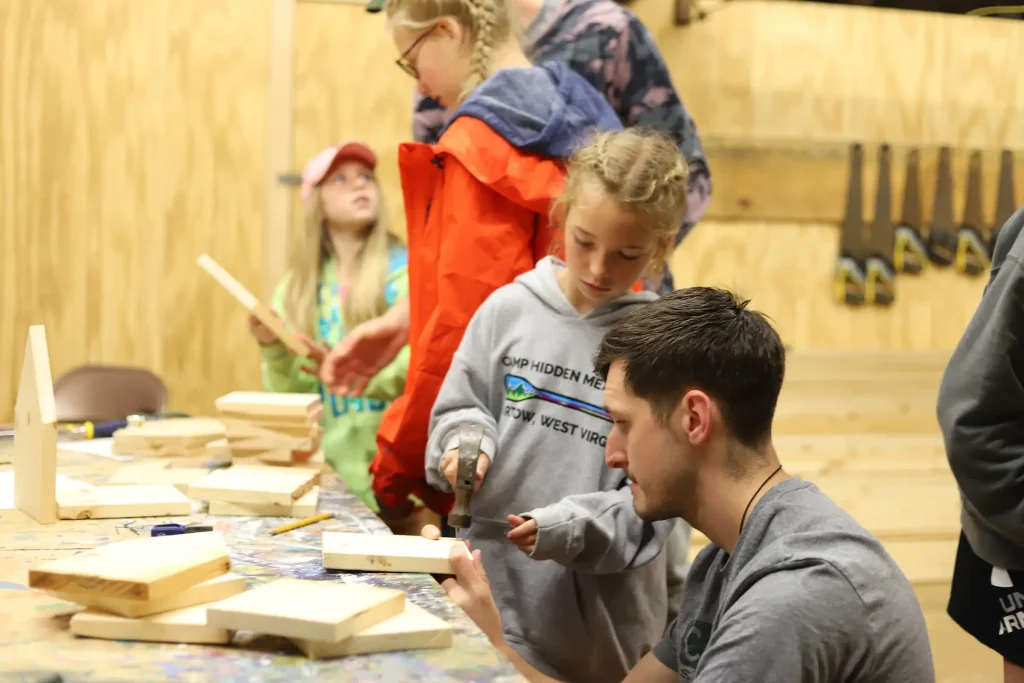 Camper and counselor doing woodworking